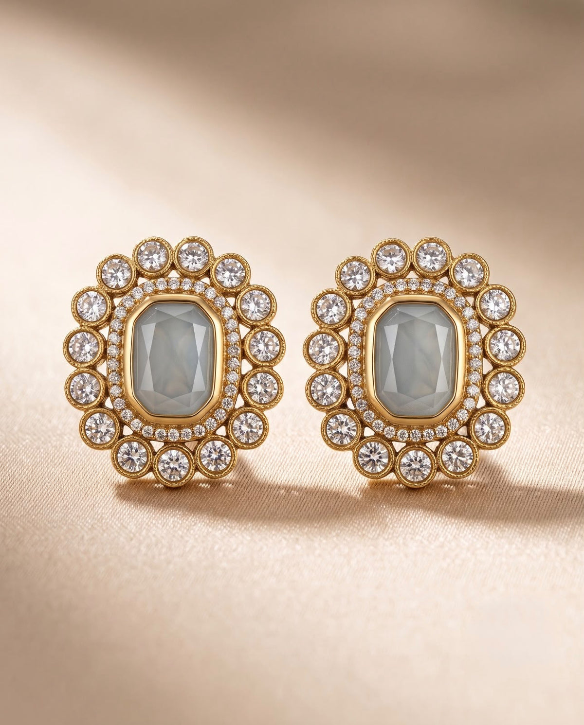 Close-up of ivory floral stud earrings with gold-tone finish and sparkling stones.