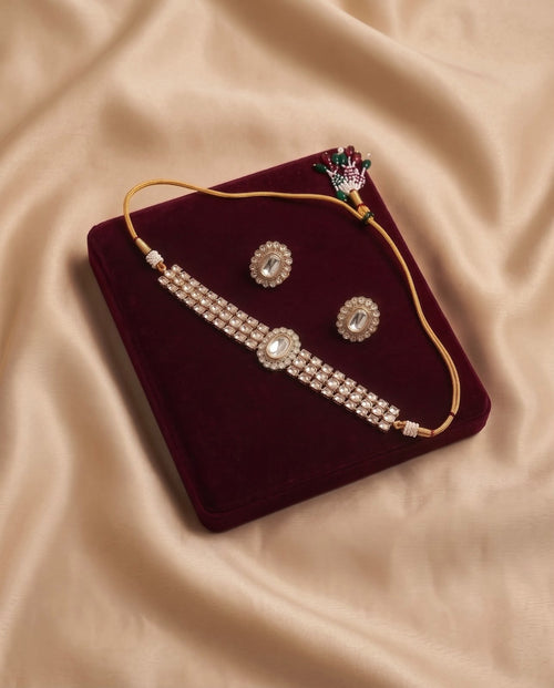 Ivory Pearl Kundan Choker Set with matching earrings displayed on a maroon velvet jewelry tray.