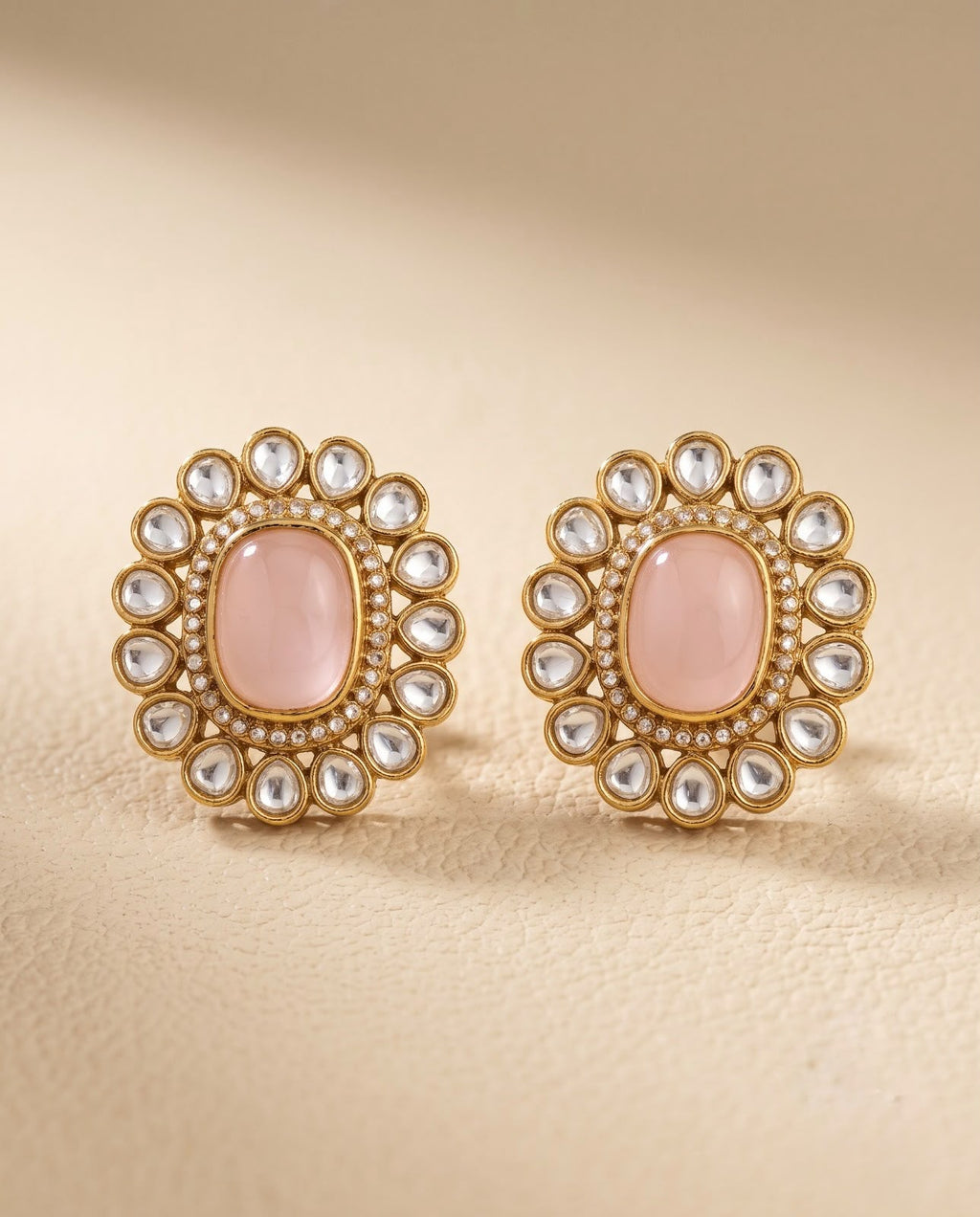 Close-up of pink kundan style stud earrings with gold-tone detailing
