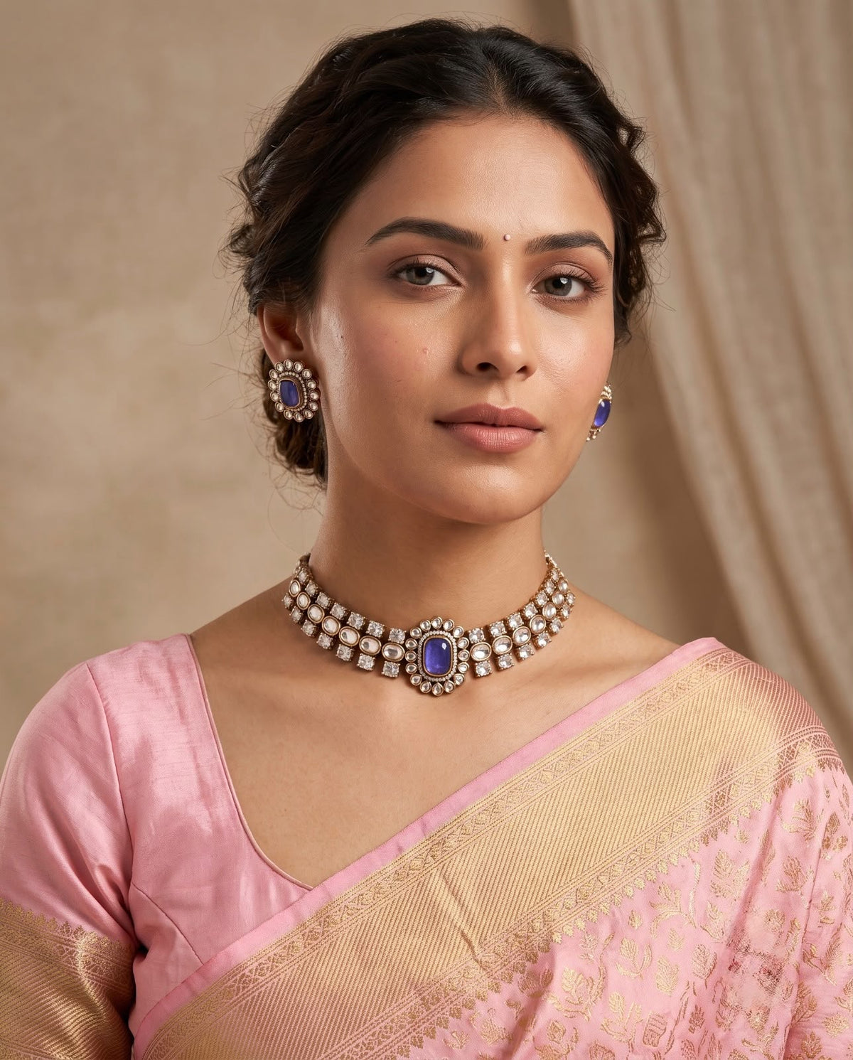 Woman wearing blue kundan choker necklace with matching earrings