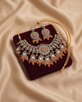 Peach kundan bridal choker necklace set with matching earrings on burgundy velvet