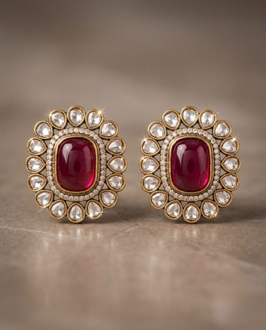 Close-up ruby red kundan style earrings with white stone detailing