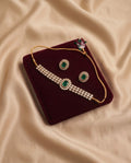Emerald green kundan necklace set with matching earrings on burgundy velvet