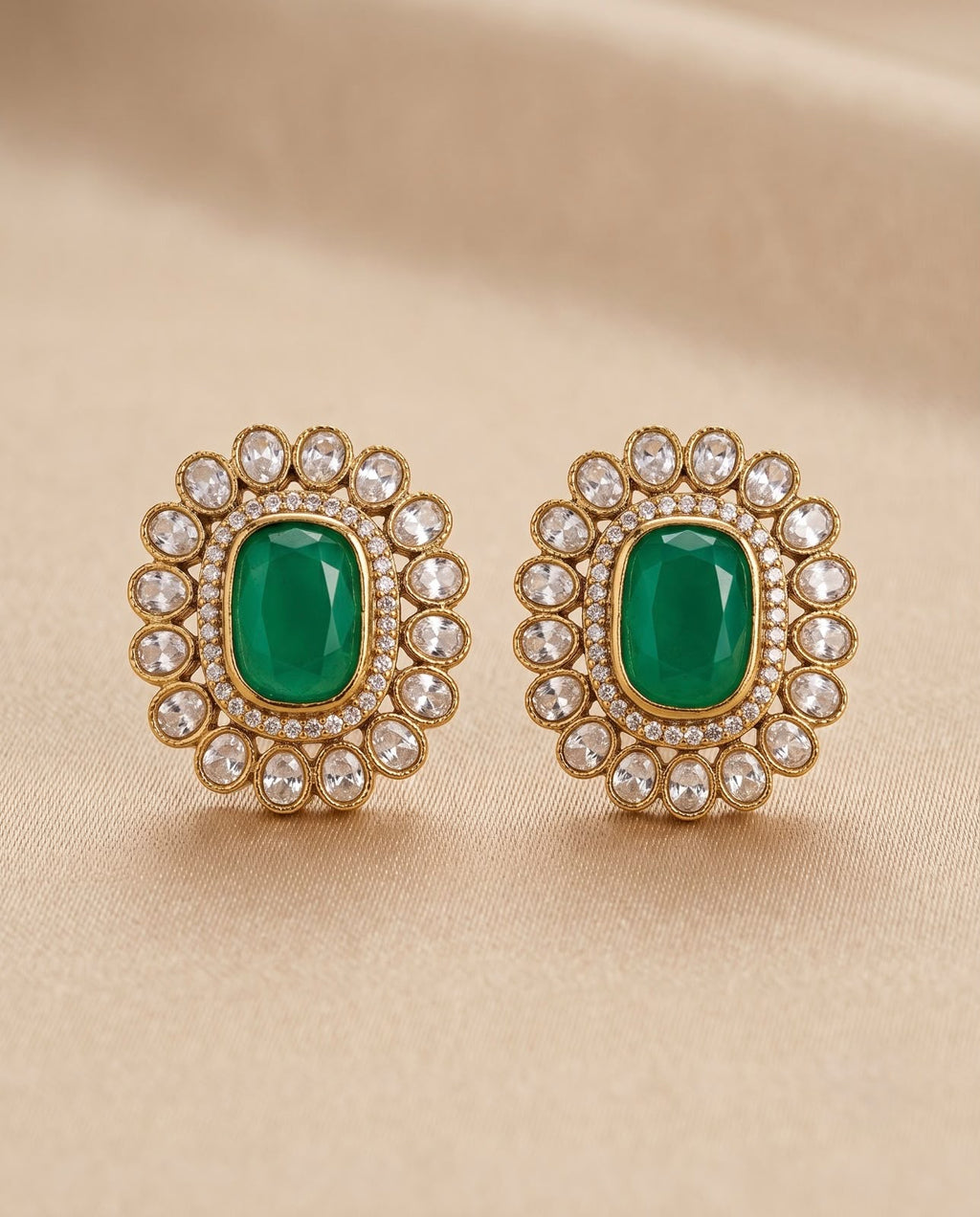 Close-up emerald green kundan style earrings with white stone detailing