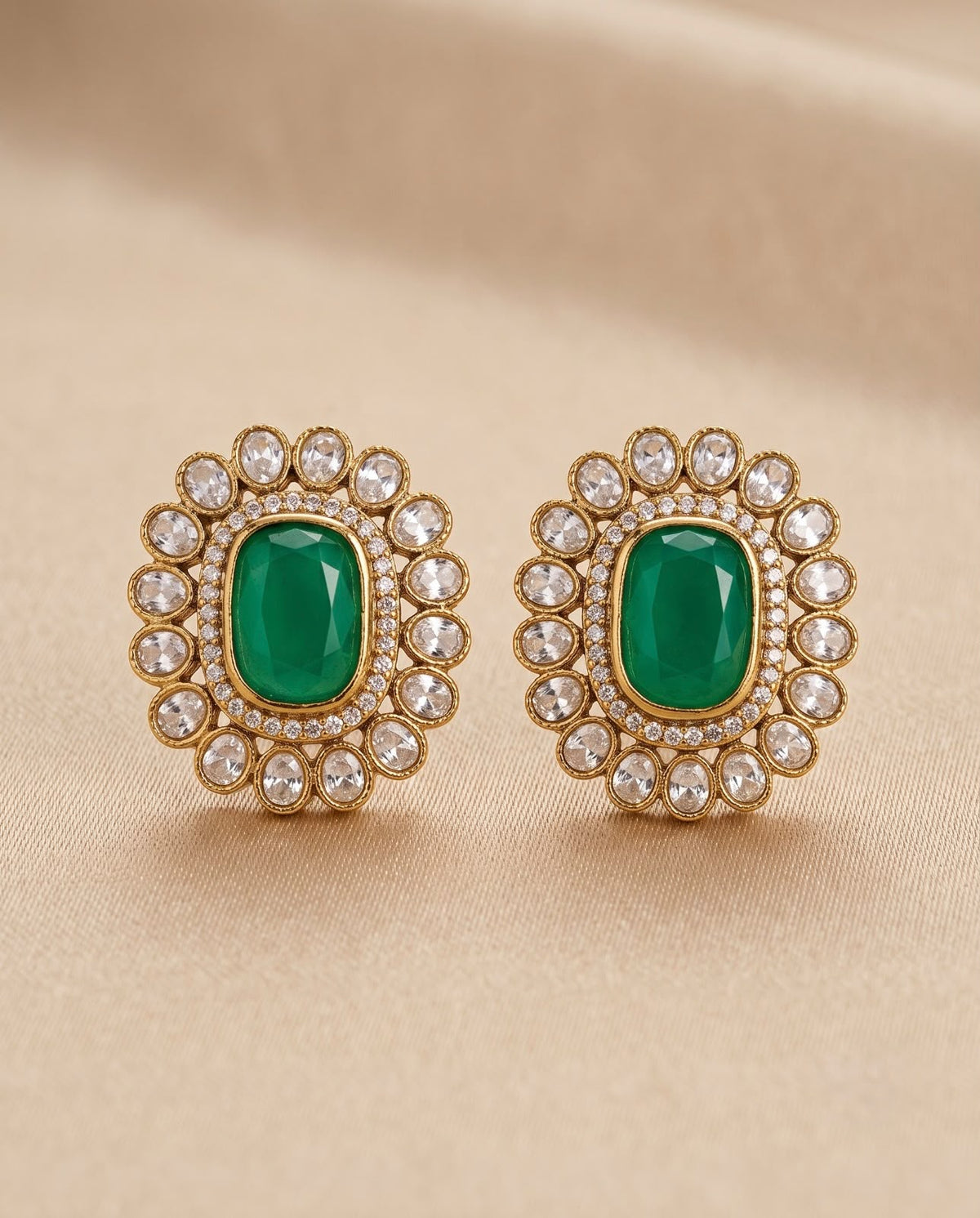 Close-up emerald green kundan style earrings with white stone detailing