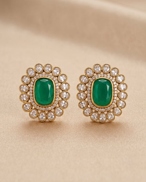 Close-up emerald green kundan style earrings with white stone detailing