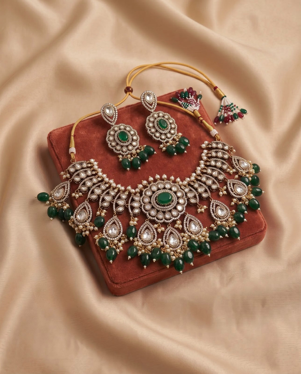 Emerald green kundan bridal necklace set with matching earrings on velvet