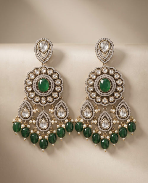 Close-up emerald green statement earrings with pearl and green bead detailing