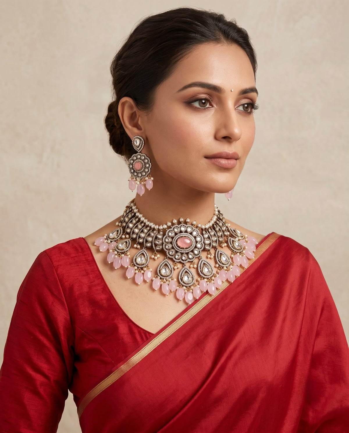 Woman wearing pink kundan bridal choker necklace set with matching earrings