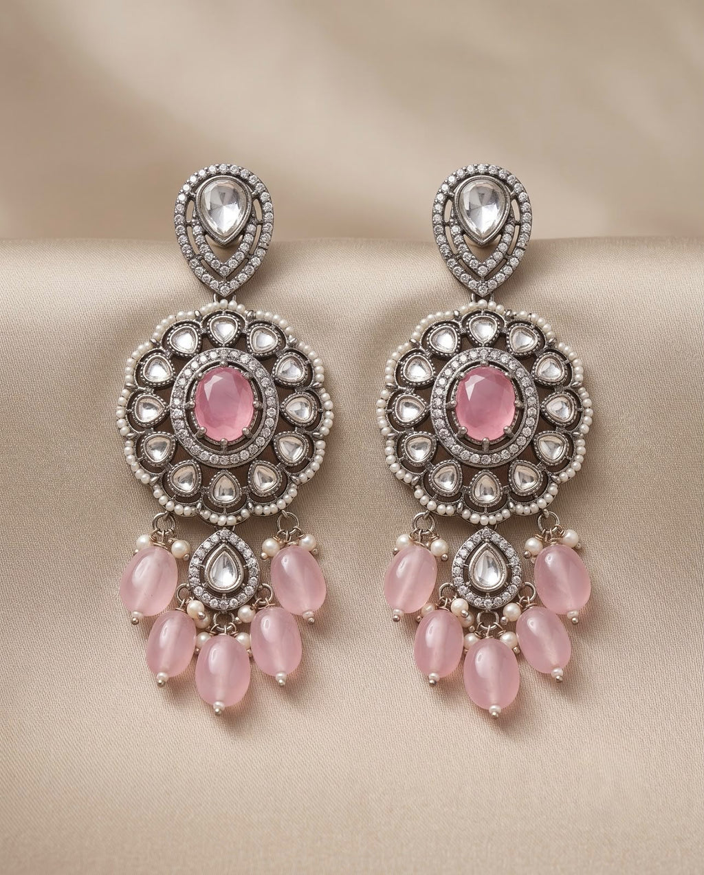 Close-up pink kundan style earrings with pearl and pink bead detailing