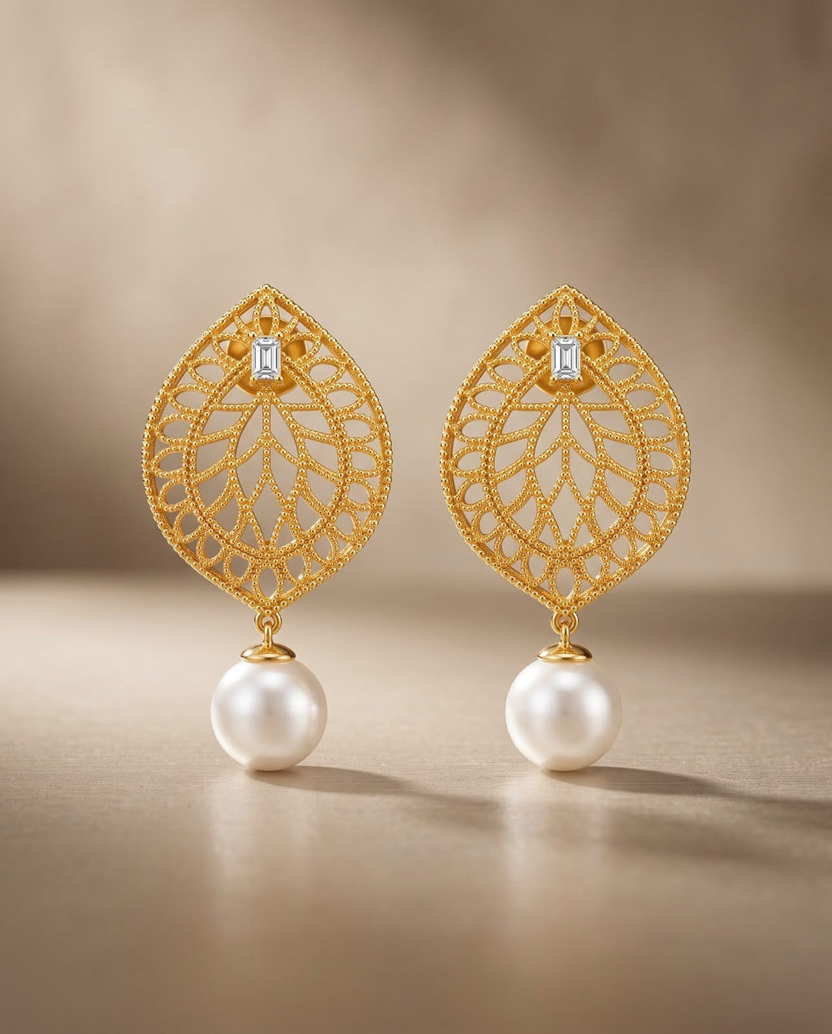 Close-up of gold teardrop earrings with pearl drops
