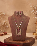 Gold ruby and pearl geometric necklace set displayed on jewellery bust