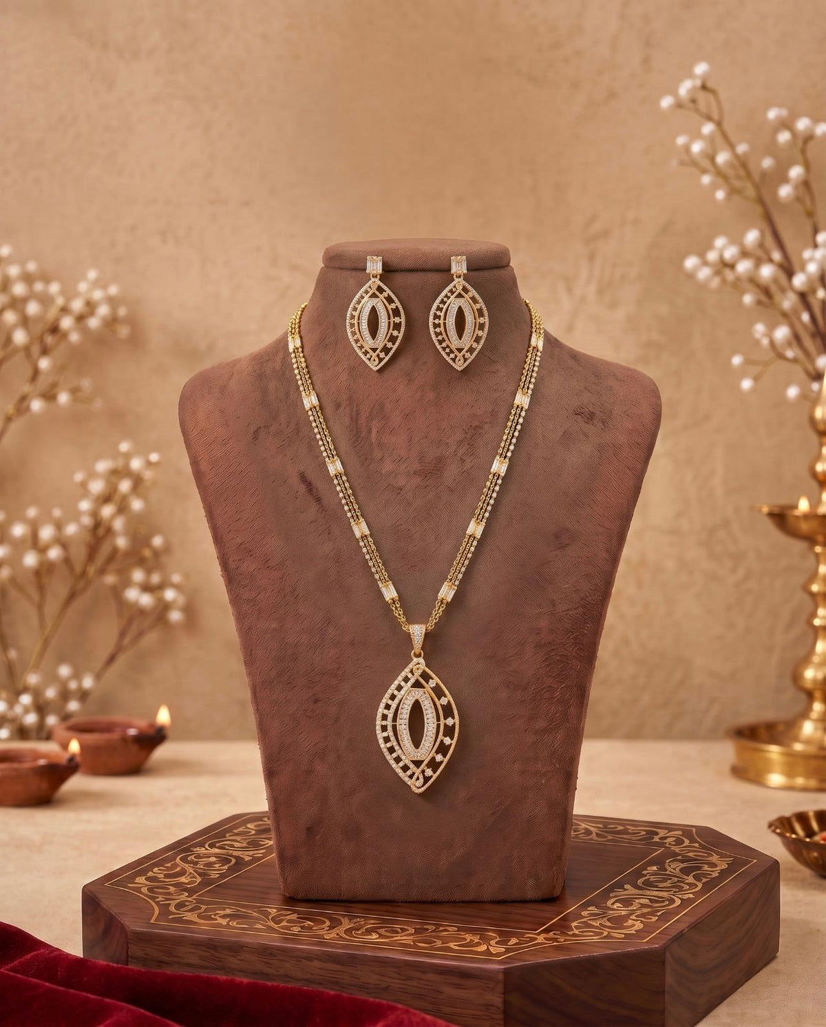 Gold-tone leaf motif necklace set displayed on jewellery bust