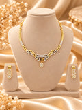 Gold-tone geometric necklace set with matching earrings on jewellery bust