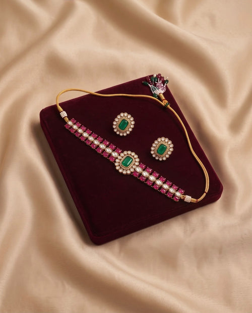 Emerald Royale Kundan Choker Set with matching earrings displayed on a maroon velvet jewelry tray.